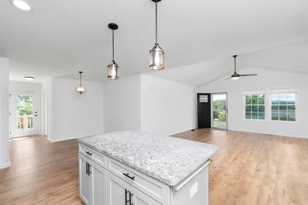 a kitchen with kitchen island a counter top space and wooden floor