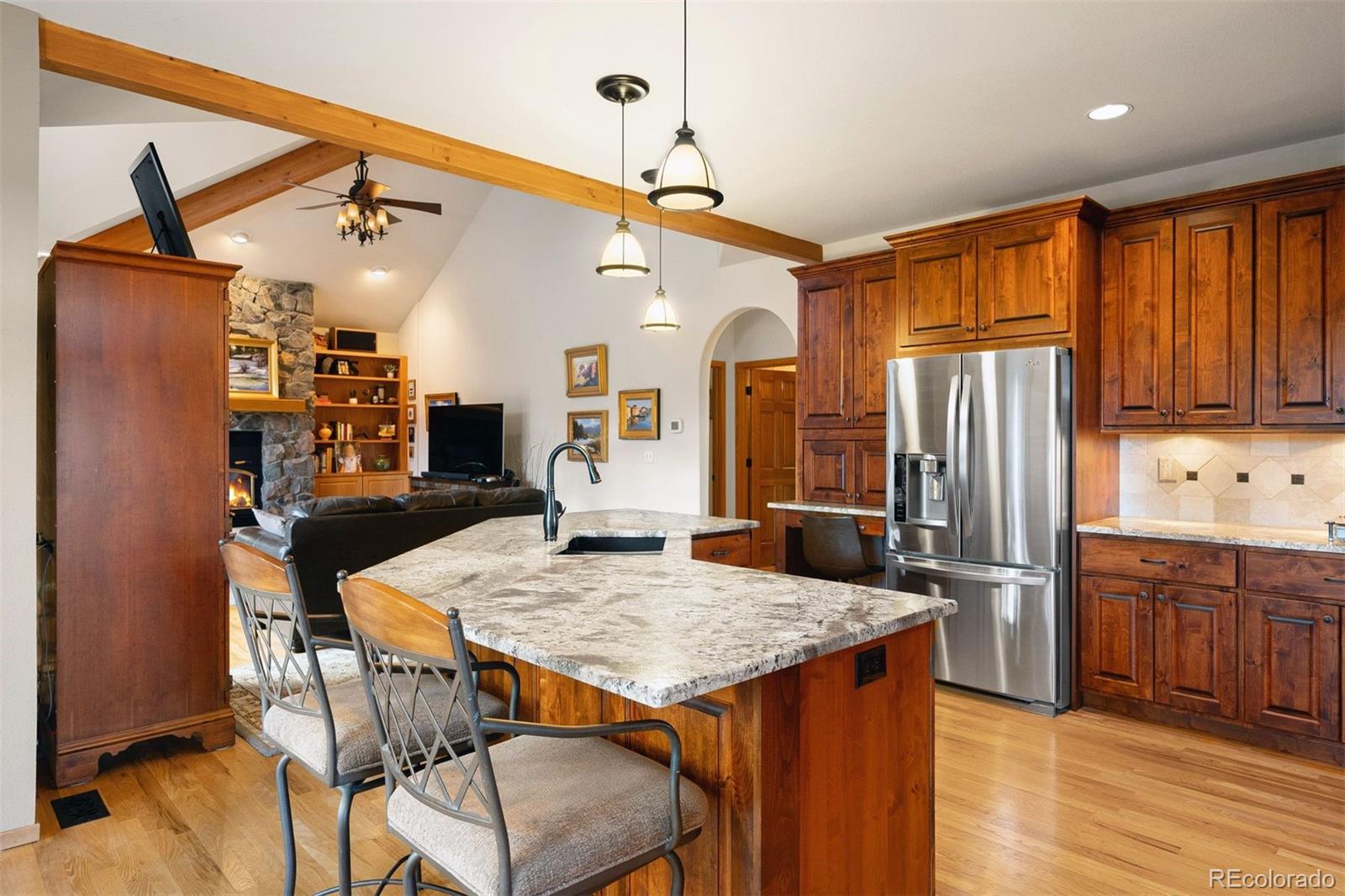 4275 Stonecliff Drive Evergreen, CO 80439 - Photo 18 of 48 a kitchen with stainless steel appliances granite countertop a kitchen island a stove a refrigerator a sink a dining table and chairs with wooden floor