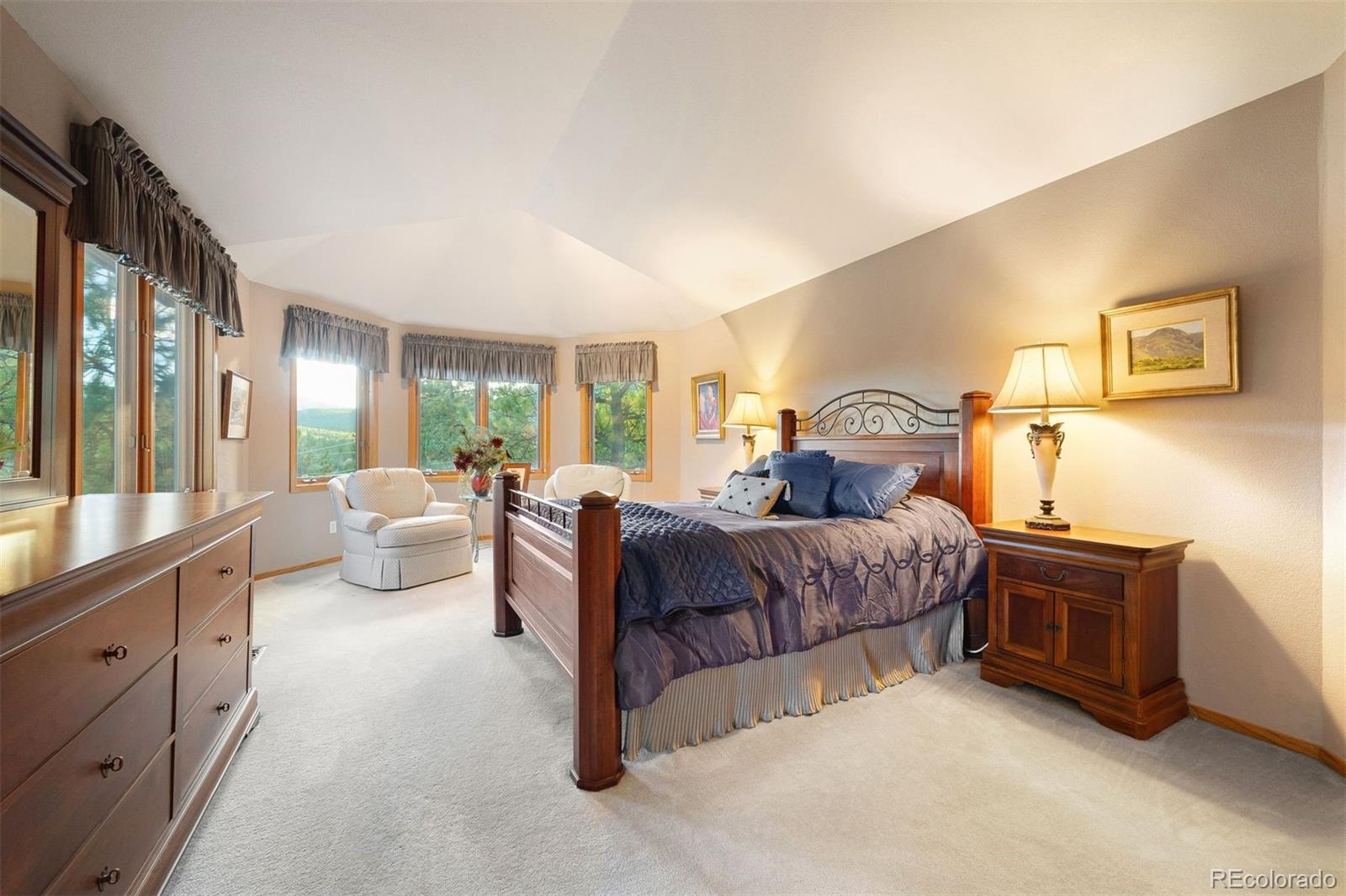 4275 Stonecliff Drive Evergreen, CO 80439 - Photo 25 of 48 a bedroom with a bed and large windows