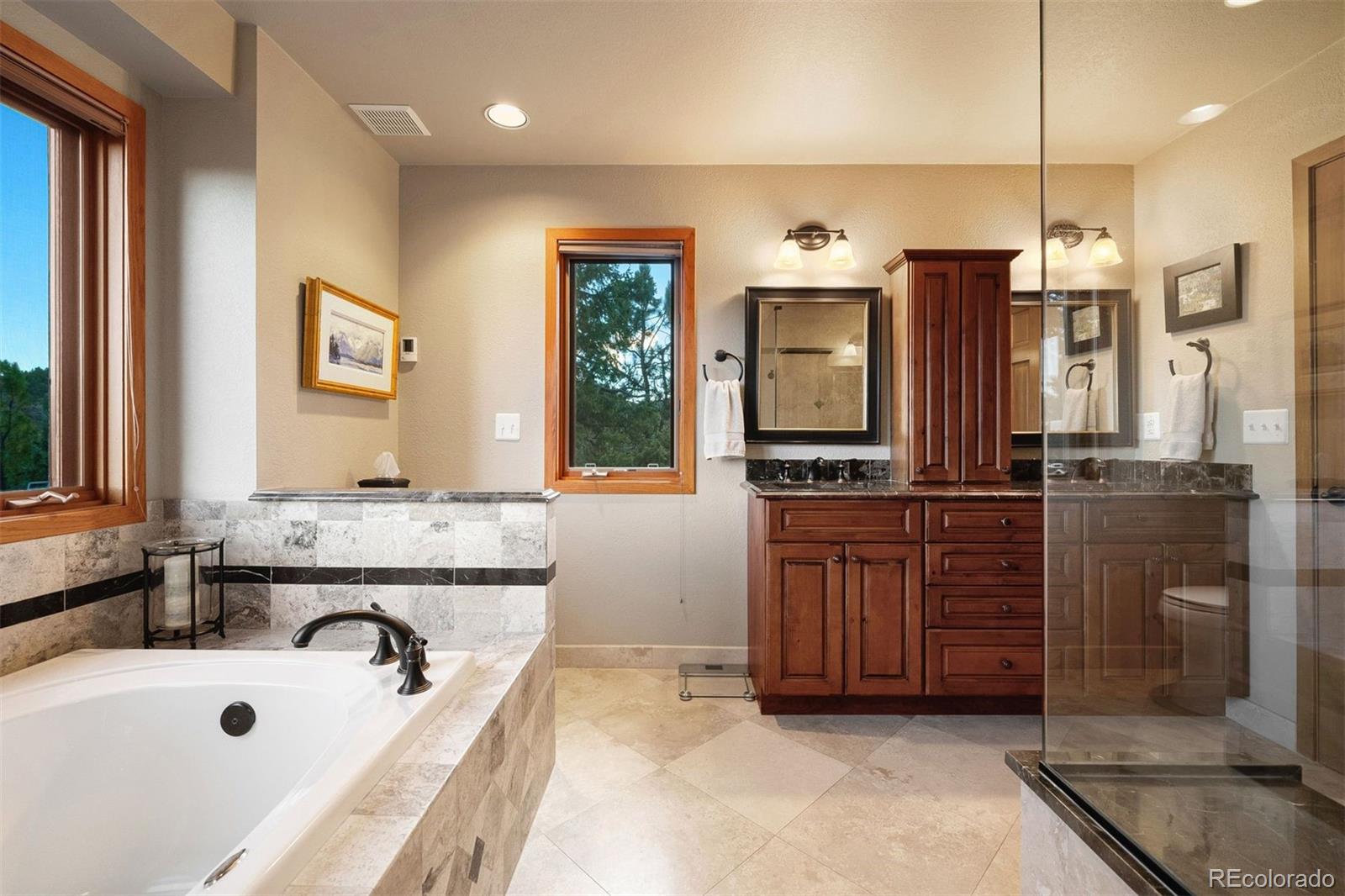 4275 Stonecliff Drive Evergreen, CO 80439 - Photo 29 of 48 a bathroom with a tub a sink and mirror
