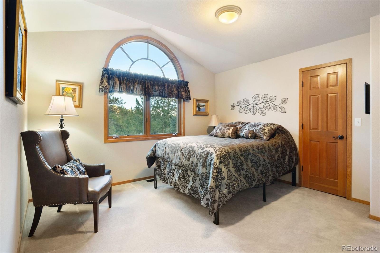 4275 Stonecliff Drive Evergreen, CO 80439 - Photo 30 of 48 a bedroom with a bed chair and a window