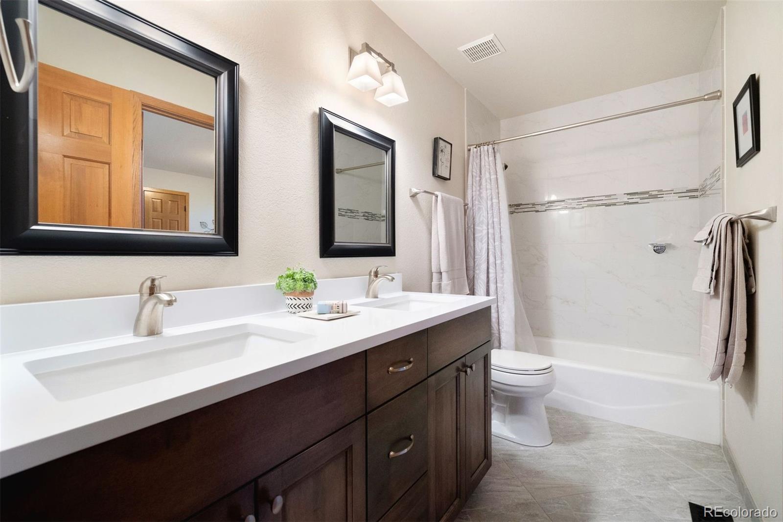 4275 Stonecliff Drive Evergreen, CO 80439 - Photo 32 of 48 a bathroom with a double vanity sink toilet mirror and bathtub