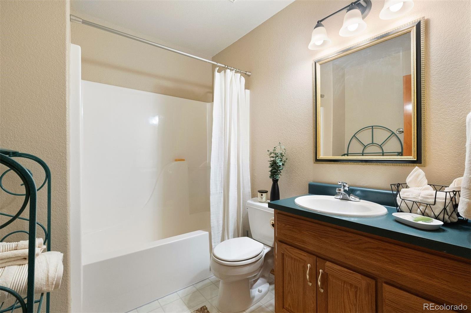 4275 Stonecliff Drive Evergreen, CO 80439 - Photo 38 of 48 a bathroom with a granite countertop sink toilet and shower