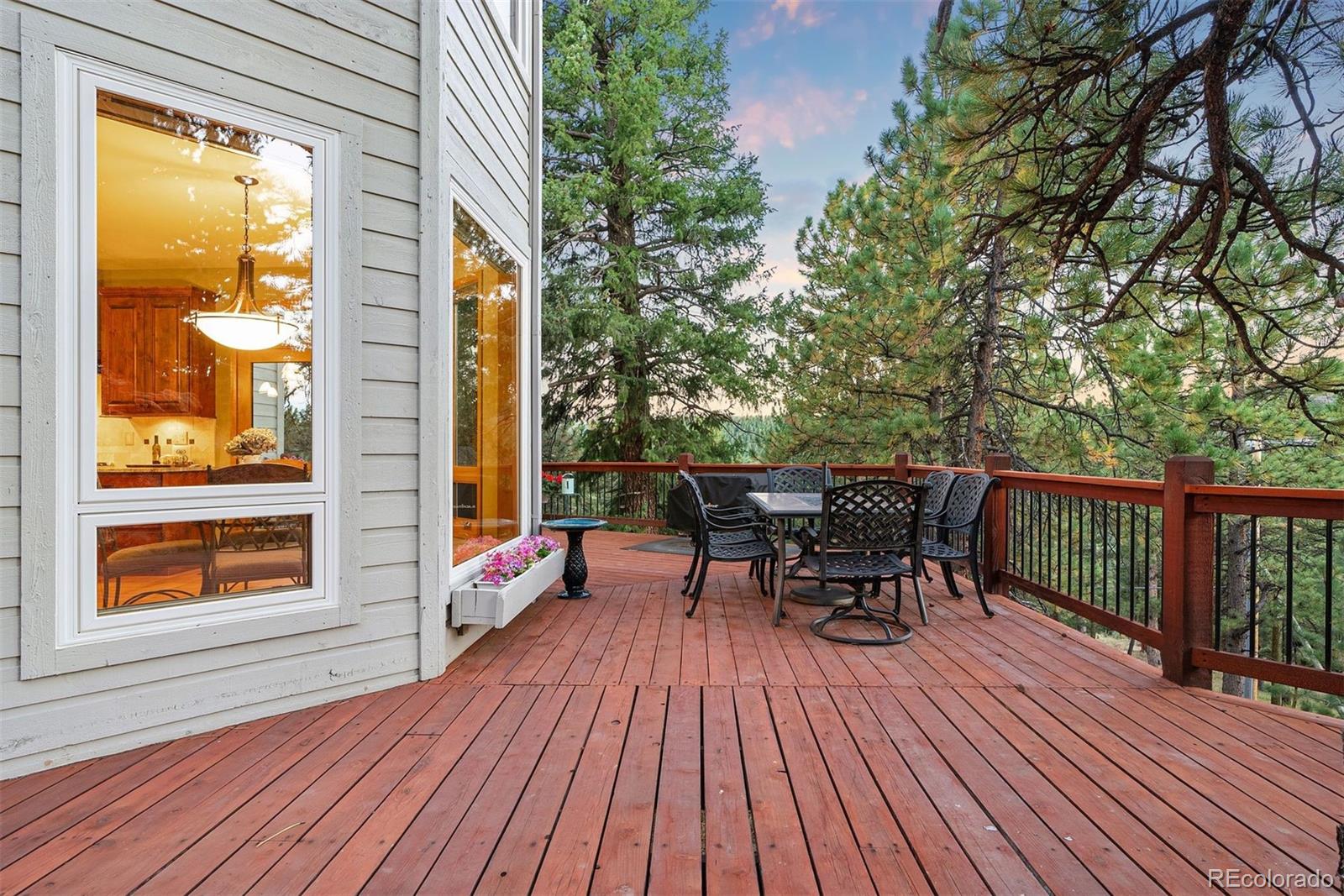 4275 Stonecliff Drive Evergreen, CO 80439 - Photo 41 of 48 a view of a deck with table and chairs and wooden floor