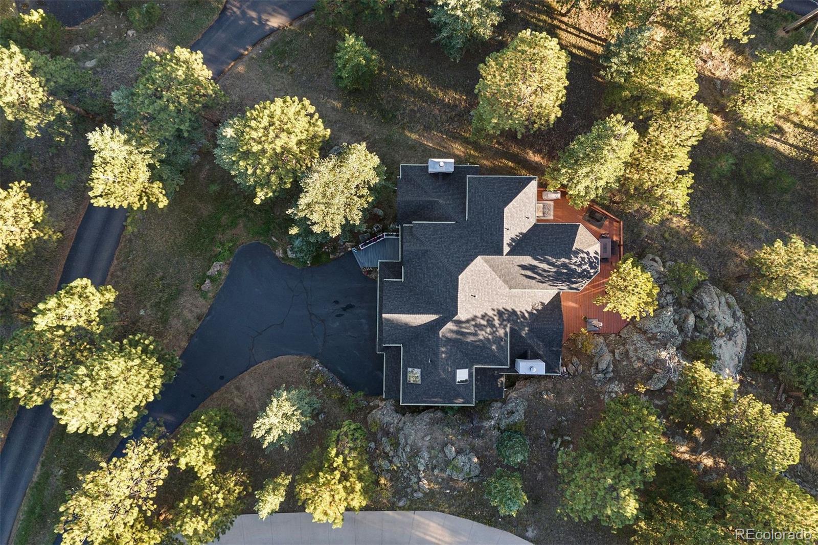 4275 Stonecliff Drive Evergreen, CO 80439 - Photo 46 of 48 a backyard of a house with a lot of flower plants