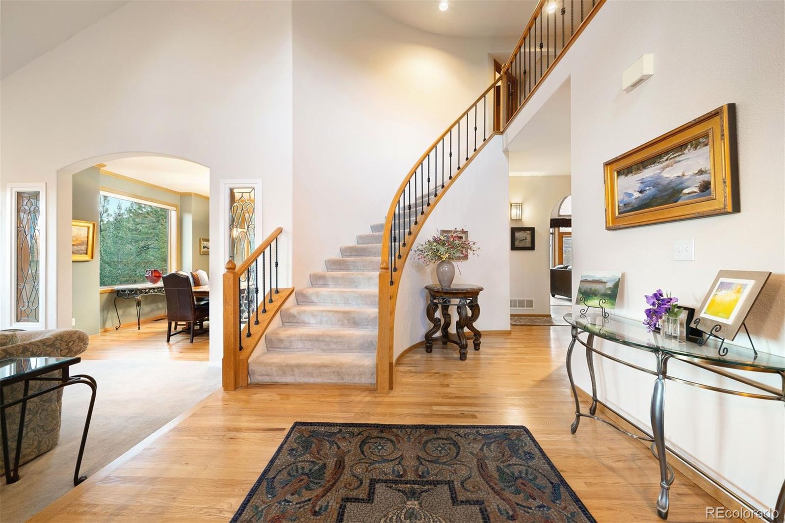 4275 Stonecliff Drive Evergreen, CO 80439 - Photo 8 of 48 a living room with furniture and a dining table with wooden floor