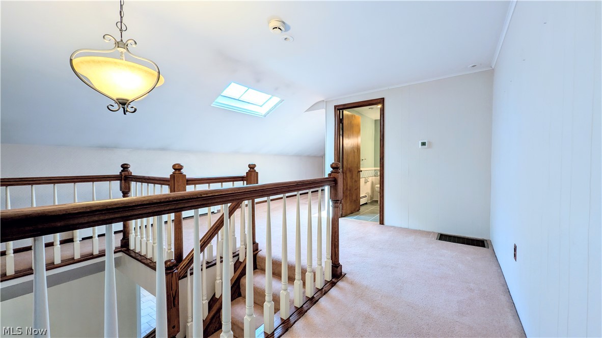 6409 Old Woods Road Ashtabula, OH 44004 - Photo 26 of 43 Carpeted landing with a wood and white spindle railing overlooking the staircase