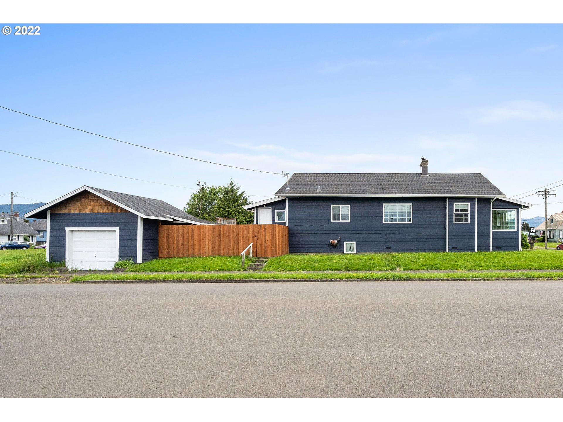 1802 8th Street Tillamook, OR 97141 - Photo 2 of 13 a front view of a house with a yard and garage