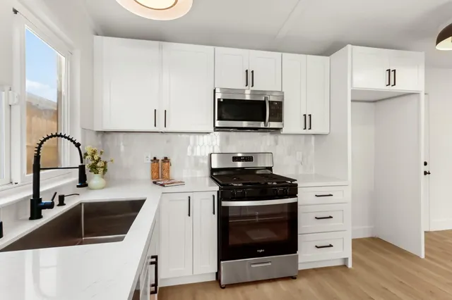 a kitchen with granite countertop a sink and a stove top oven