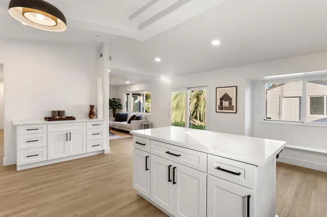 a kitchen with white cabinets and appliances