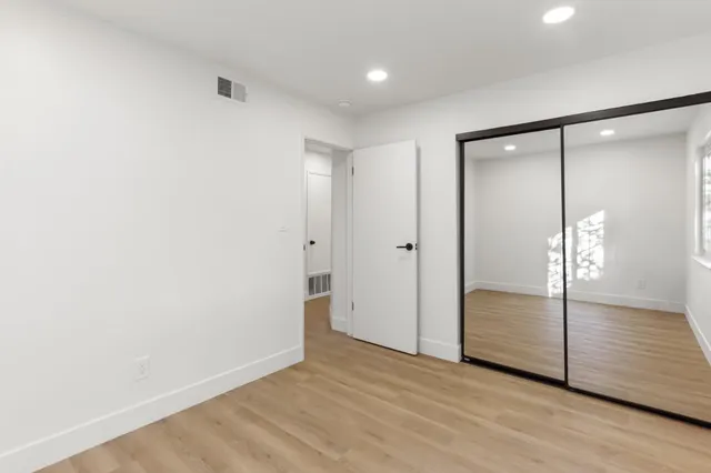 an empty room with wooden floor and door