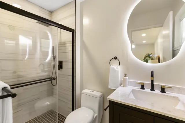 a bathroom with a sink a toilet and a mirror