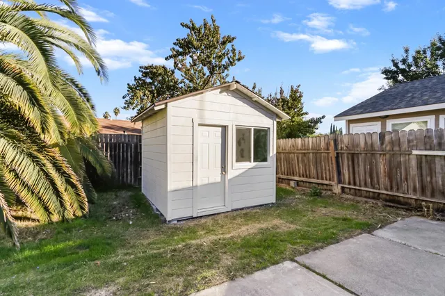 a white house that has tree in front of it