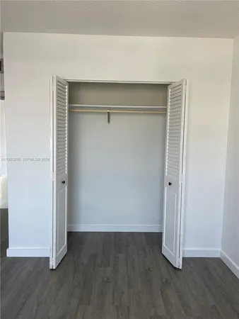 an empty room with wooden floor and closet