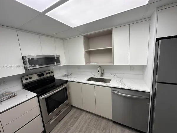 a kitchen with a sink stove and refrigerator