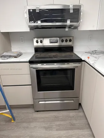 a stove top oven sitting inside of a kitchen