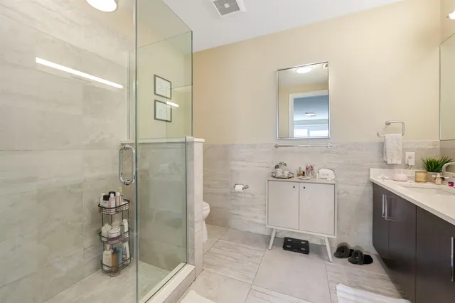 a bathroom with a shower sink and mirror