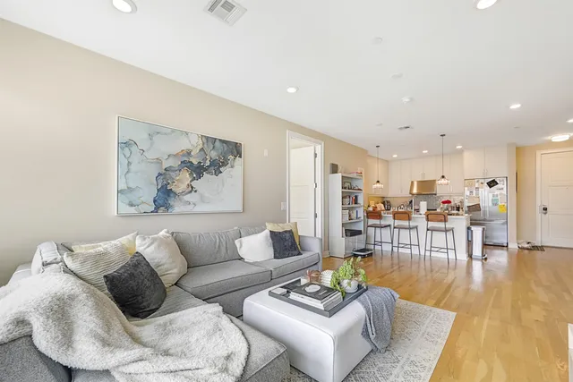 a living room with furniture and kitchen view
