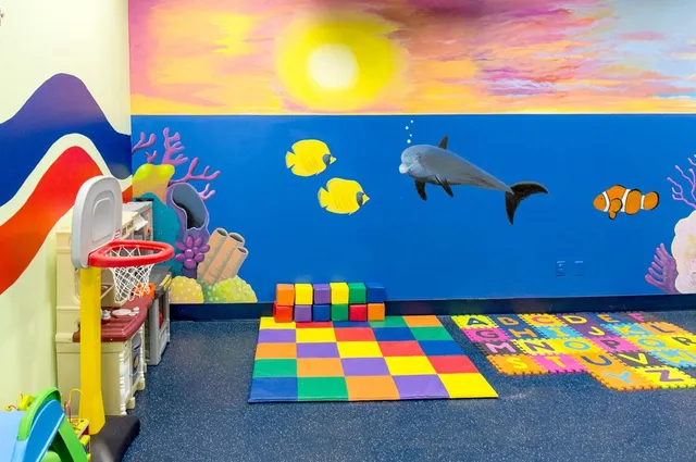 a view of play room with toys and wooden floor