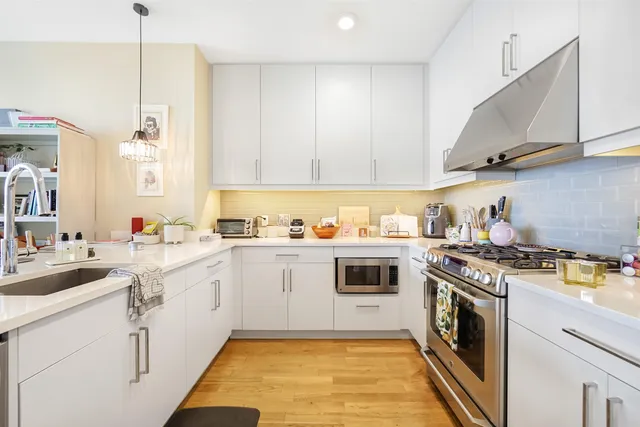 a kitchen with a stove sink and cabinets