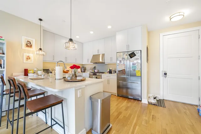 a kitchen with kitchen island a stove a table and chairs in it