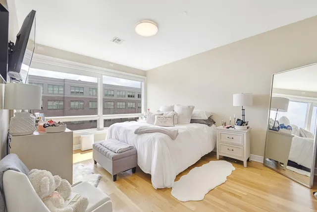 a spacious bedroom with a bed and large windows