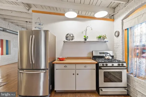 a view of a dining room with furniture a chandelier and large windows