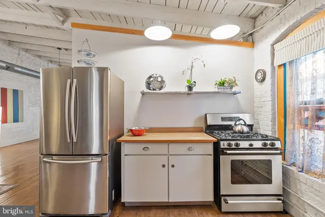 a view of a dining room with furniture a chandelier and large windows