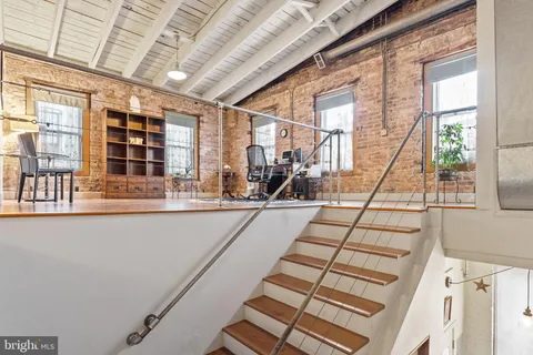 a dining room with stainless steel appliances granite countertop a table chairs and a refrigerator