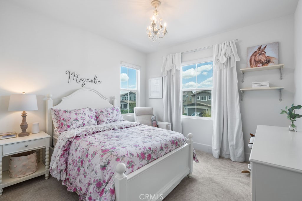 32166 Verbena Way Temecula, CA 92591 - Photo 28 of 47 a bedroom with a large bed and a chandelier