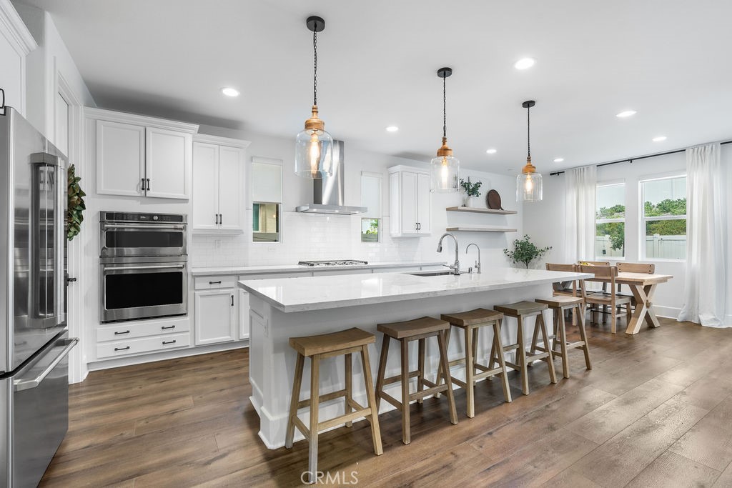 32166 Verbena Way Temecula, CA 92591 - Photo 6 of 47 a large kitchen with kitchen island a large island in white appliances