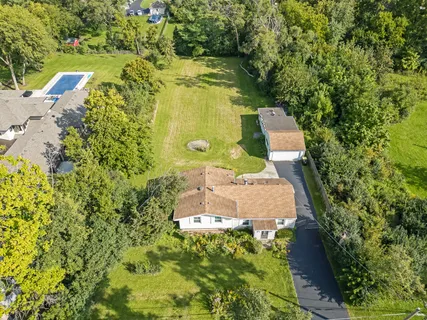 an aerial view of a house with swimming pool and garden