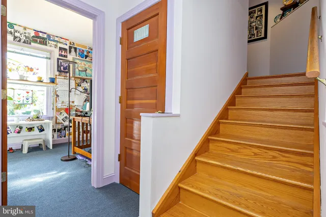 a view of kitchen island with stainless steel appliances granite countertop a sink a stove and a wooden floor
