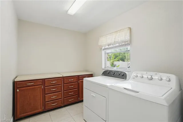 a utility room with dryer washer and a window