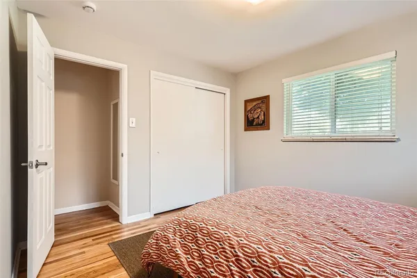 a bedroom with a bed and wooden floor