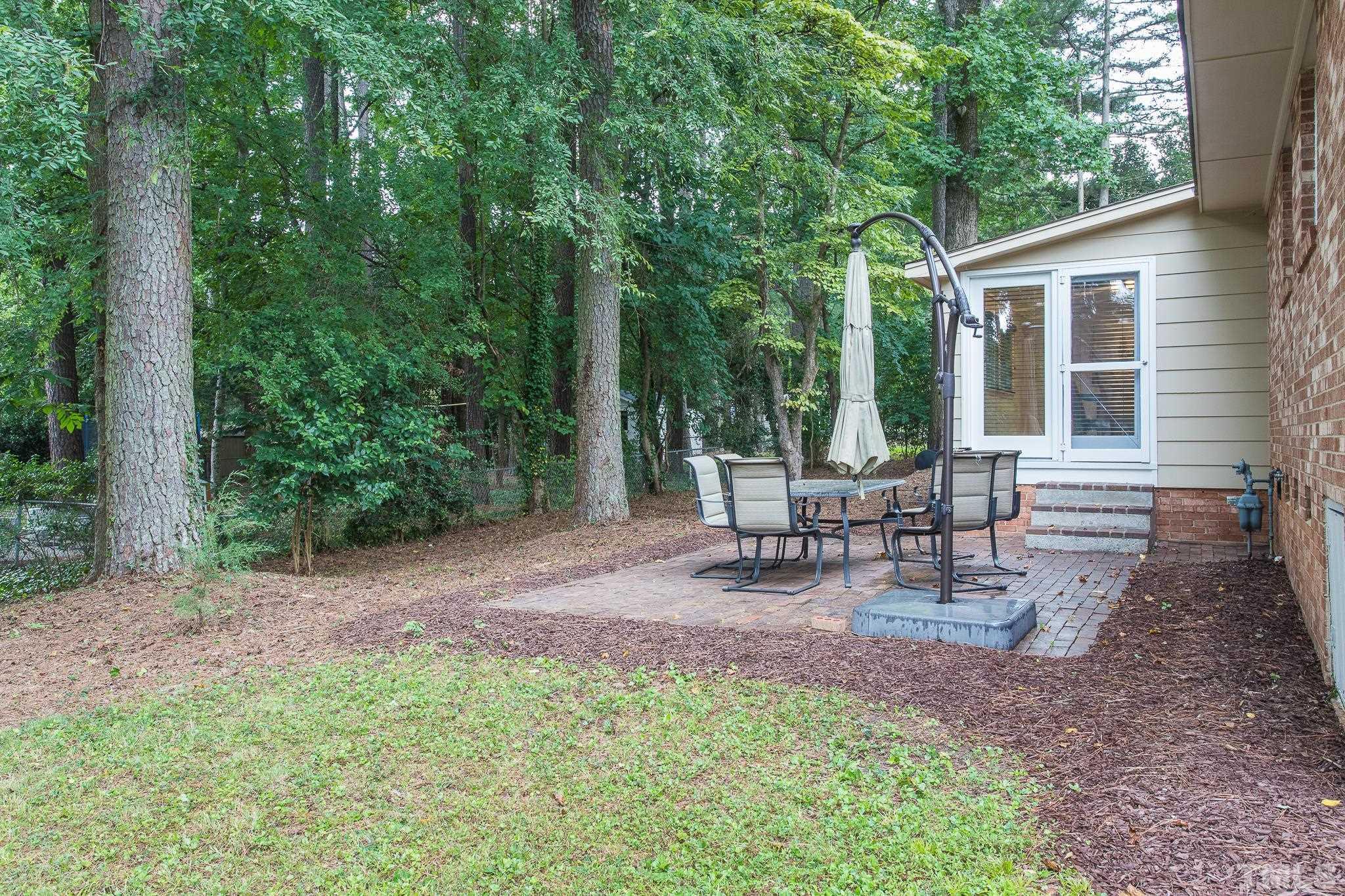 636 Duke Drive Raleigh, NC 27609 - Photo 16 of 19 Wooded backyard with a brick patio.