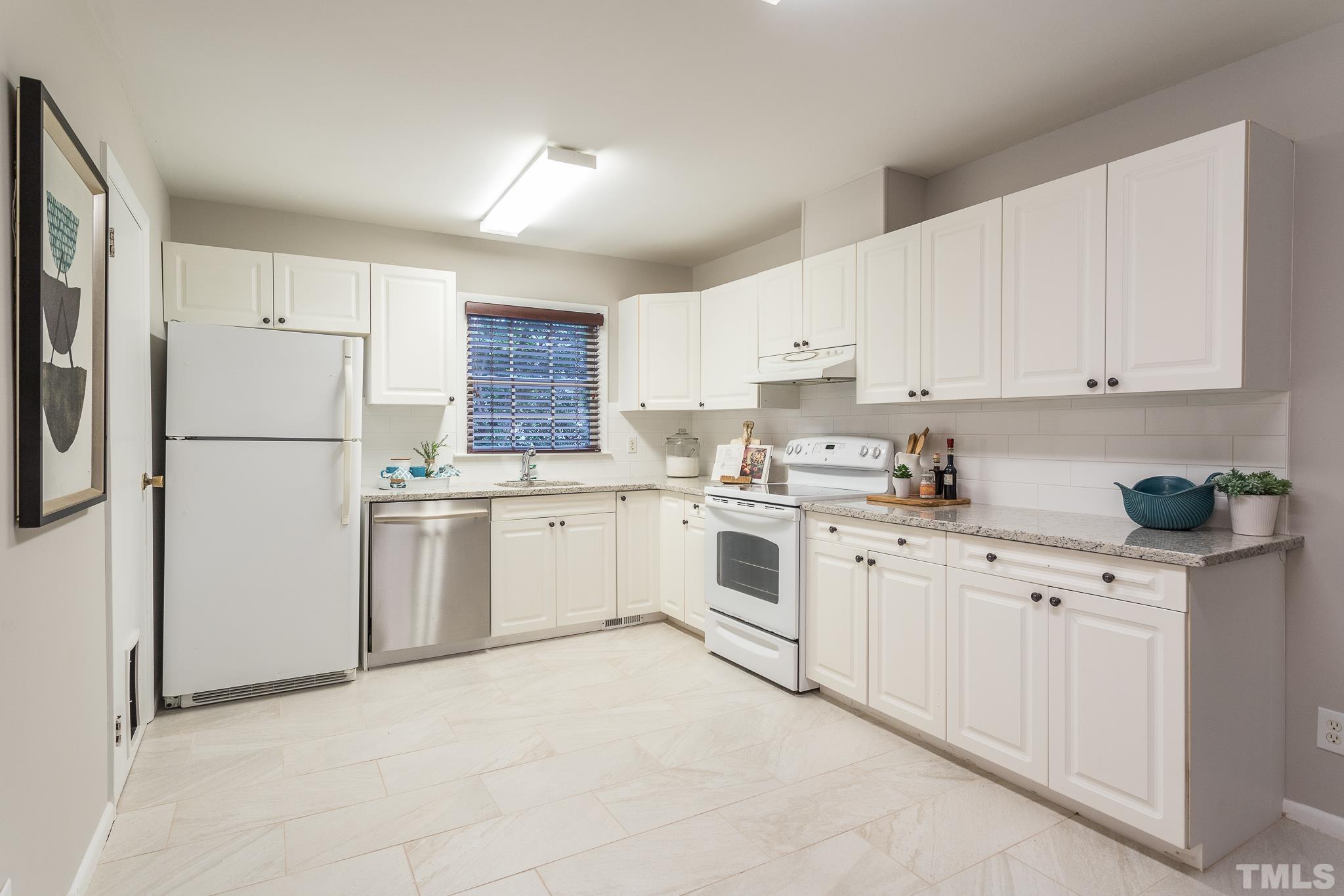 636 Duke Drive Raleigh, NC 27609 - Photo 6 of 19 Kitchen has newly installed tile floors and granite counter tops with backsplash