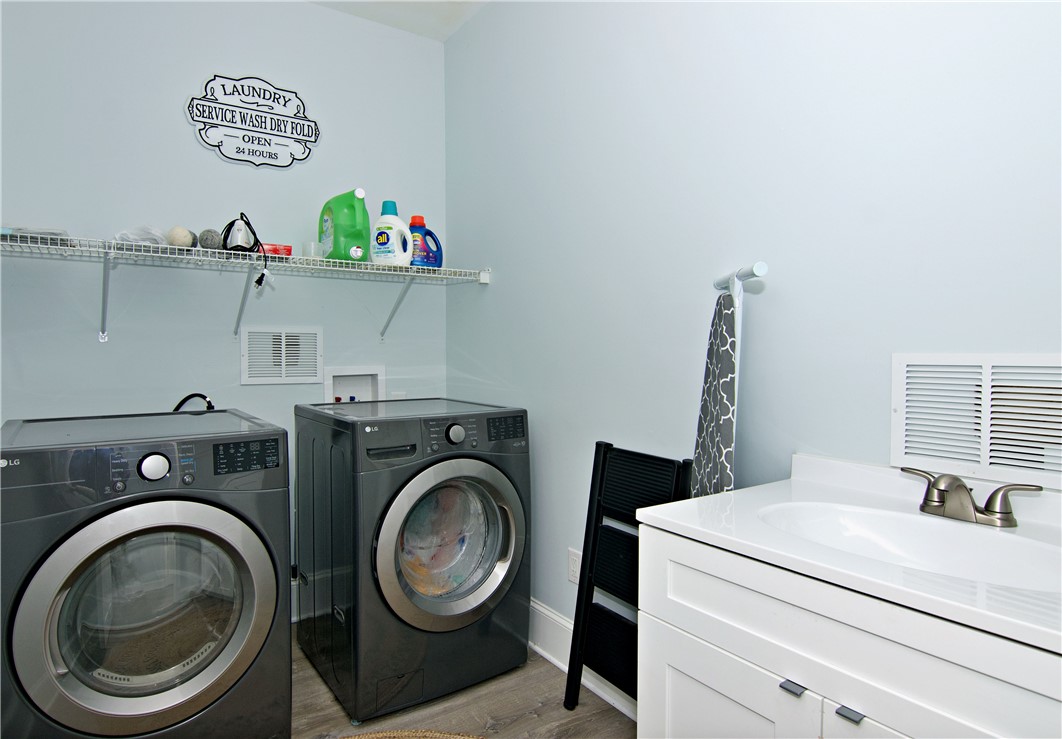 206 Petty Road Seneca, SC 29672 - Photo 26 of 49 Smooth wood-look flooring and a modern vanity highlight this functional dedicated laundry space.