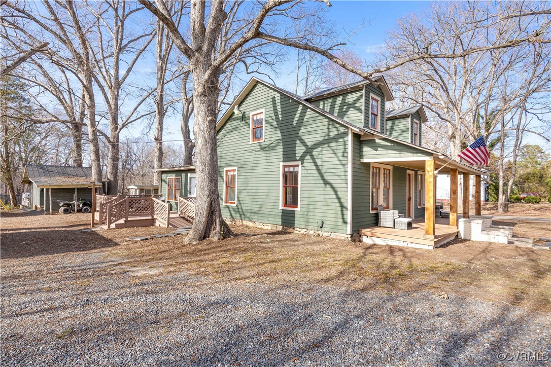 View of property exterior with a deck and a porch