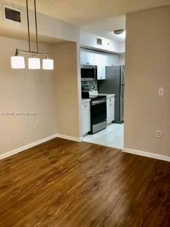 a view of a kitchen with a sink and dishwasher a refrigerator with wooden floor