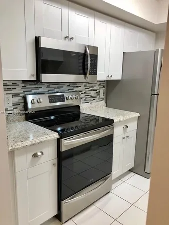 a kitchen with stainless steel appliances a stove a microwave and a refrigerator