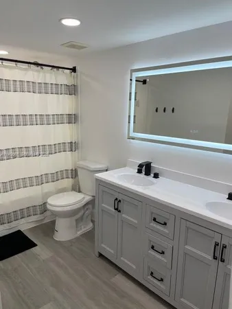 a bathroom with a sink a toilet and shower