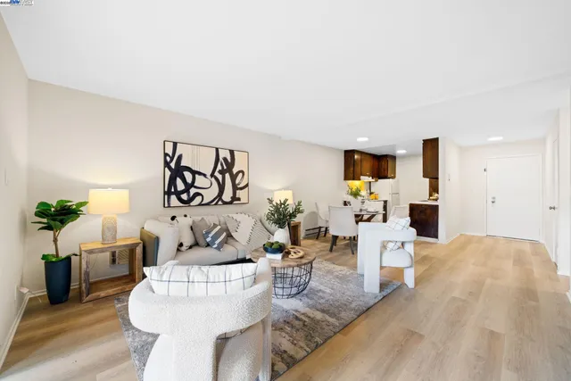 a living room with furniture and view of kitchen
