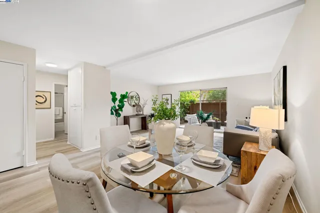 a view of a dining room with furniture a potted plant and wooden floor