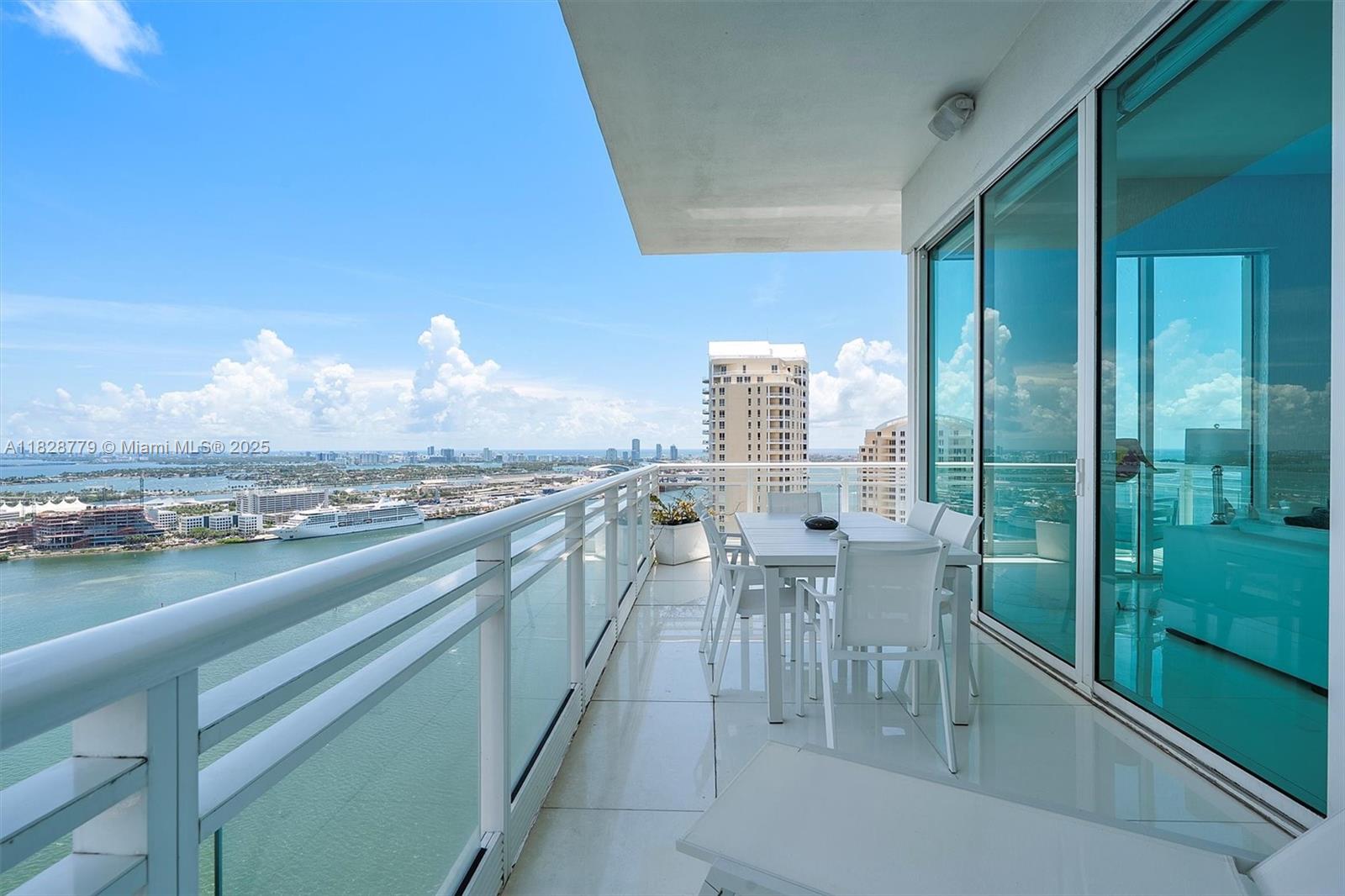 900 Brickell Key Boulevard, Unit 3103 Miami, FL 33131 - Photo 11 of 55 a view of a city from a balcony with dining table & chairs