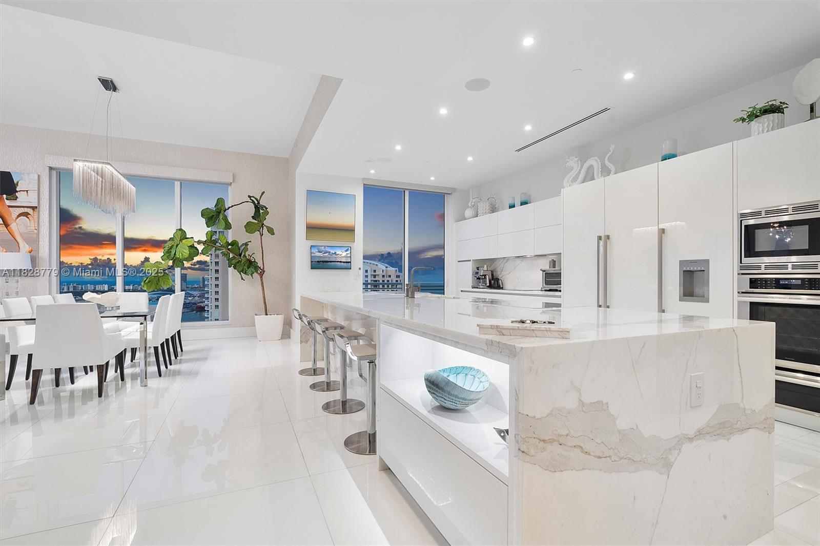 900 Brickell Key Boulevard, Unit 3103 Miami, FL 33131 - Photo 33 of 55 a large white kitchen with lots of counter space and furniture