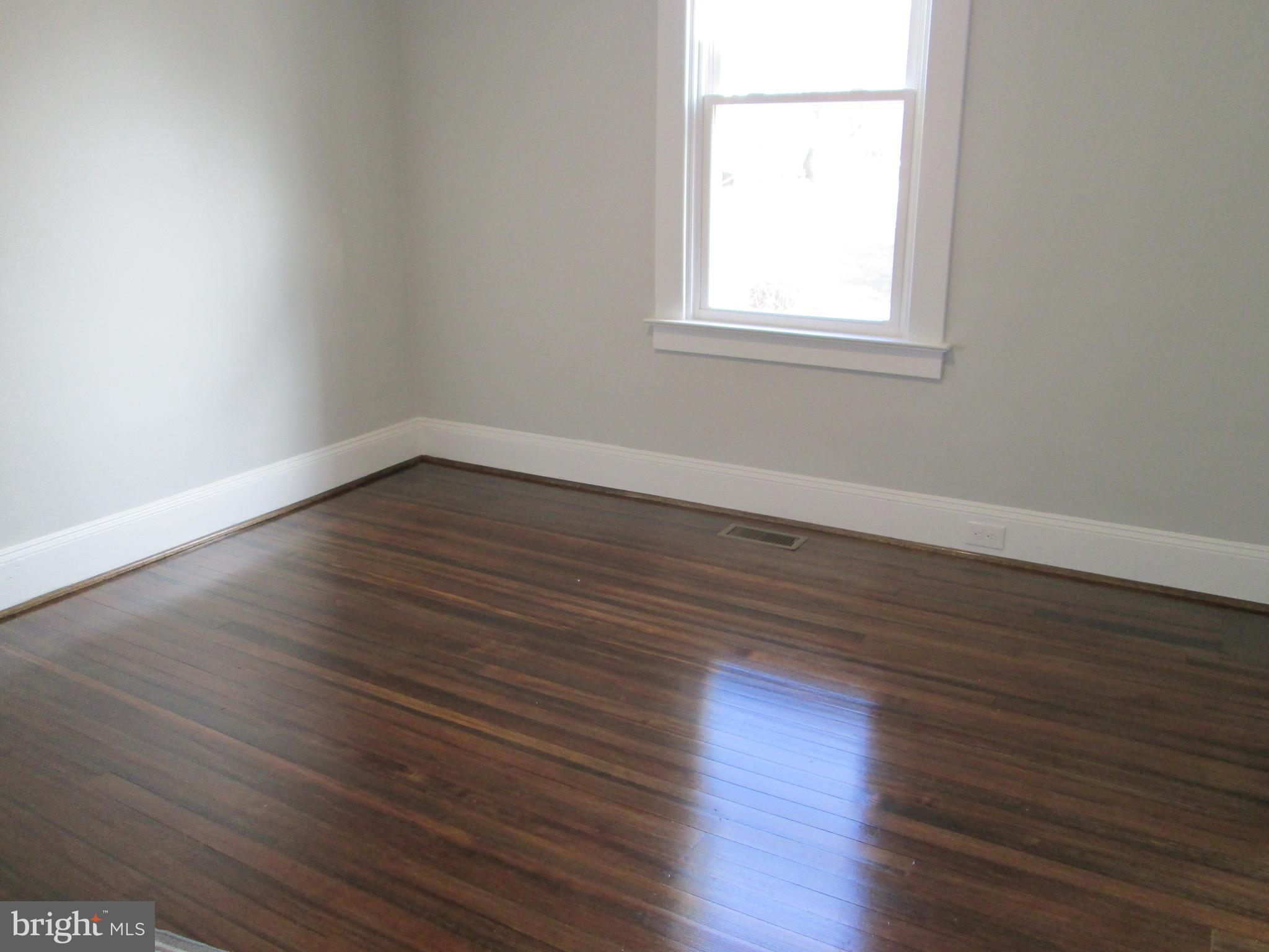 205 Wicklow Road Glen Burnie, MD 21061 - Photo 13 of 52 an empty room with wooden floor and windows