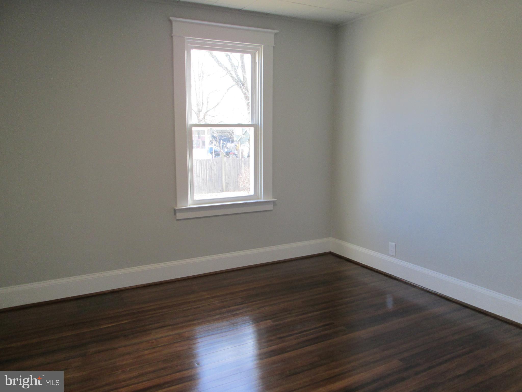 205 Wicklow Road Glen Burnie, MD 21061 - Photo 41 of 52 a view of an empty room with wooden floor and a window