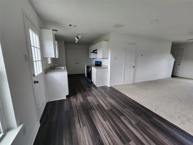 a view of a living room with furniture and wooden floor