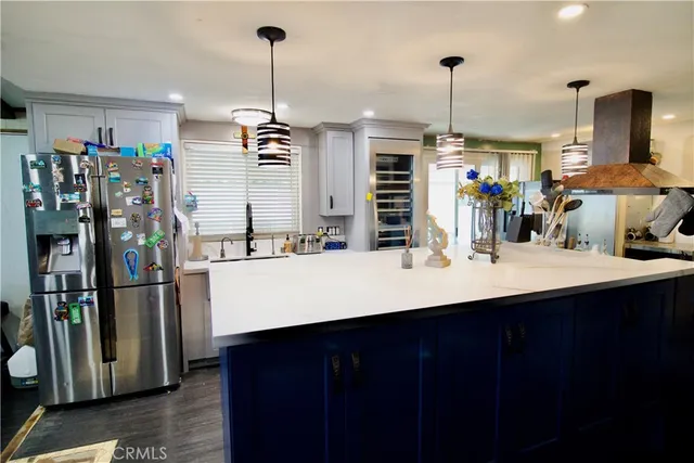 a kitchen with refrigerator and chairs